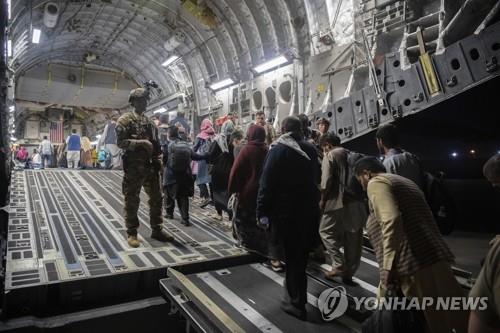 미군 경비 속 수송기 탑승하는 아프간 피란민들 